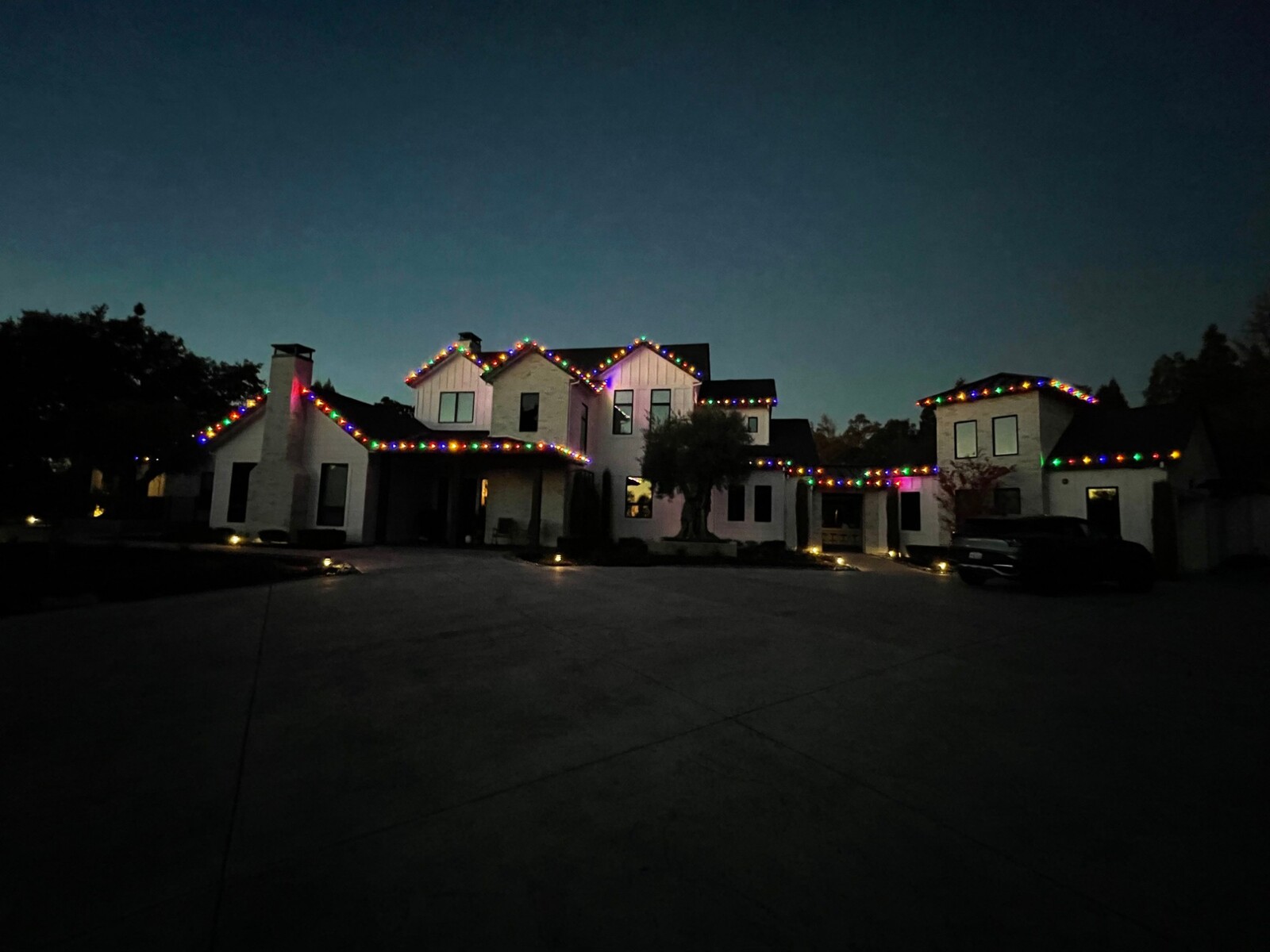 Holiday light installation in Carmichael, CA: modern farmhouse multicolor roofline dusk